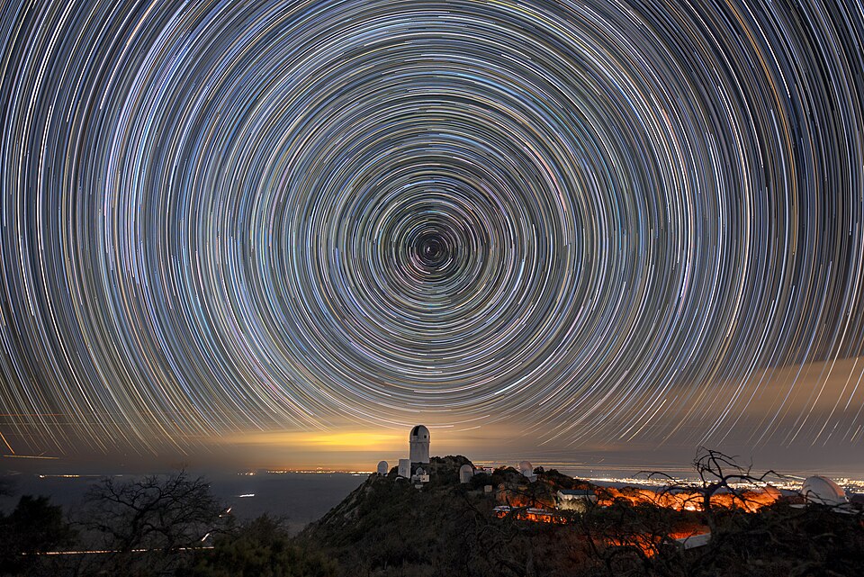 Star trail night sky over Kitt Peak National Observatory, showing circular star paths above the mountains and the order of Yahuah’s creation.